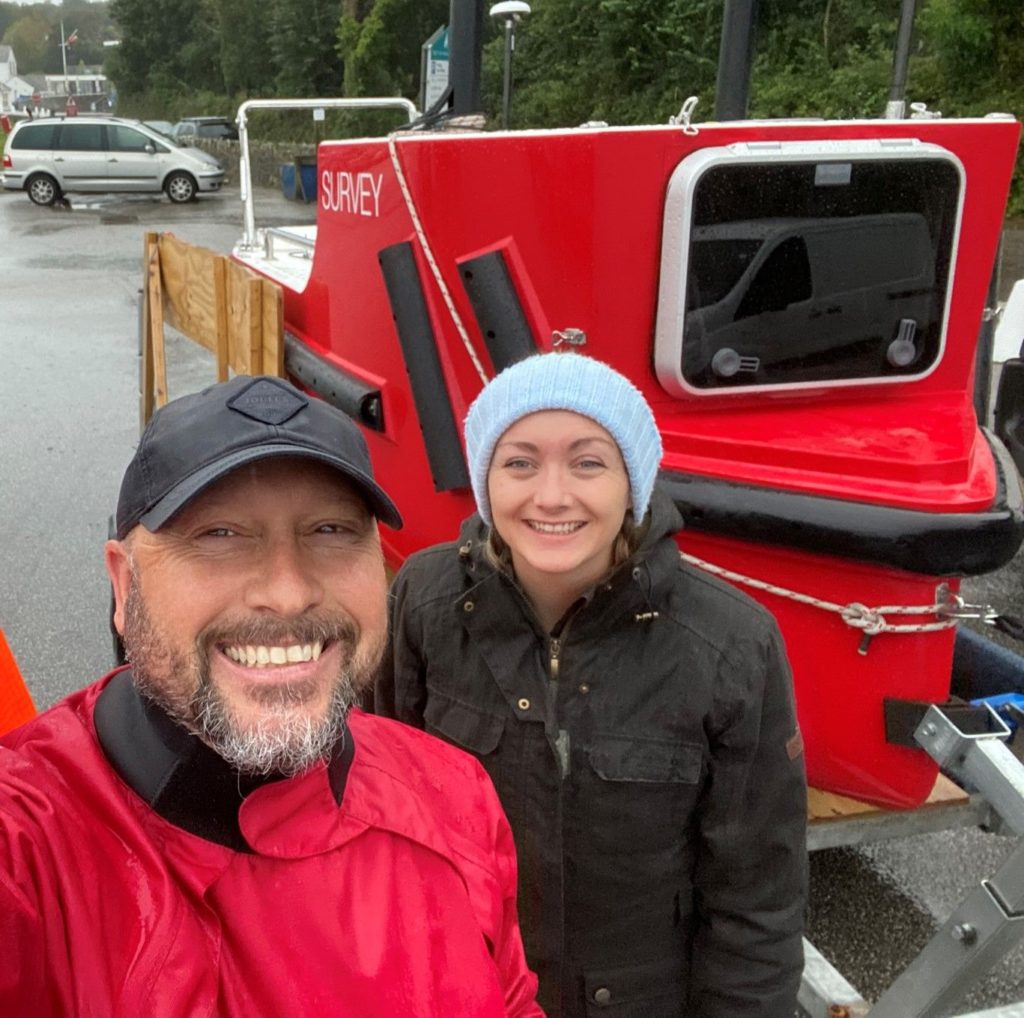 Smiling couple in front of large red trailer